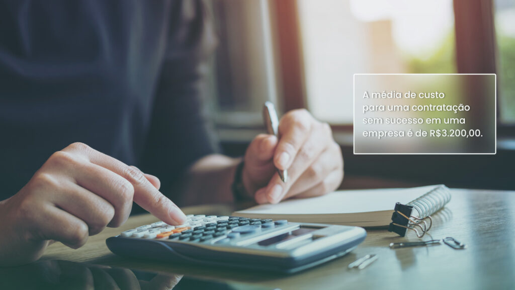 Pessoa mexendo em calculadora para entender o custo de contratação na empresa e entender como reduzir o custo.