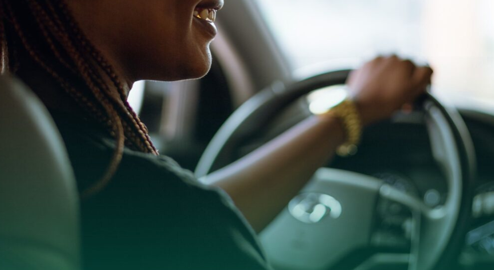 Checagem de veículos mostrando um carro em destaque com lupa sobreposto, representando a análise de histórico e verificação de dívidas, restrições e segurança antes da compra ou uso empresarial.