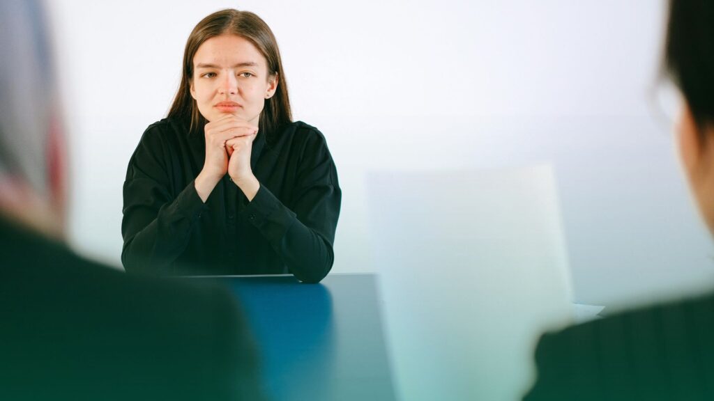 candidata tendo o seu currículo analisado por uma recrutadora em um ambiente corporativo.