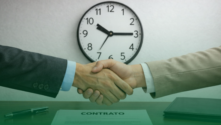 Duas pessoas apertando as mãos sobre um contrato, com um relógio na parede simbolizando prazo determinado.
